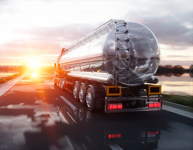 Fuel tanker truck on a road at sunset
